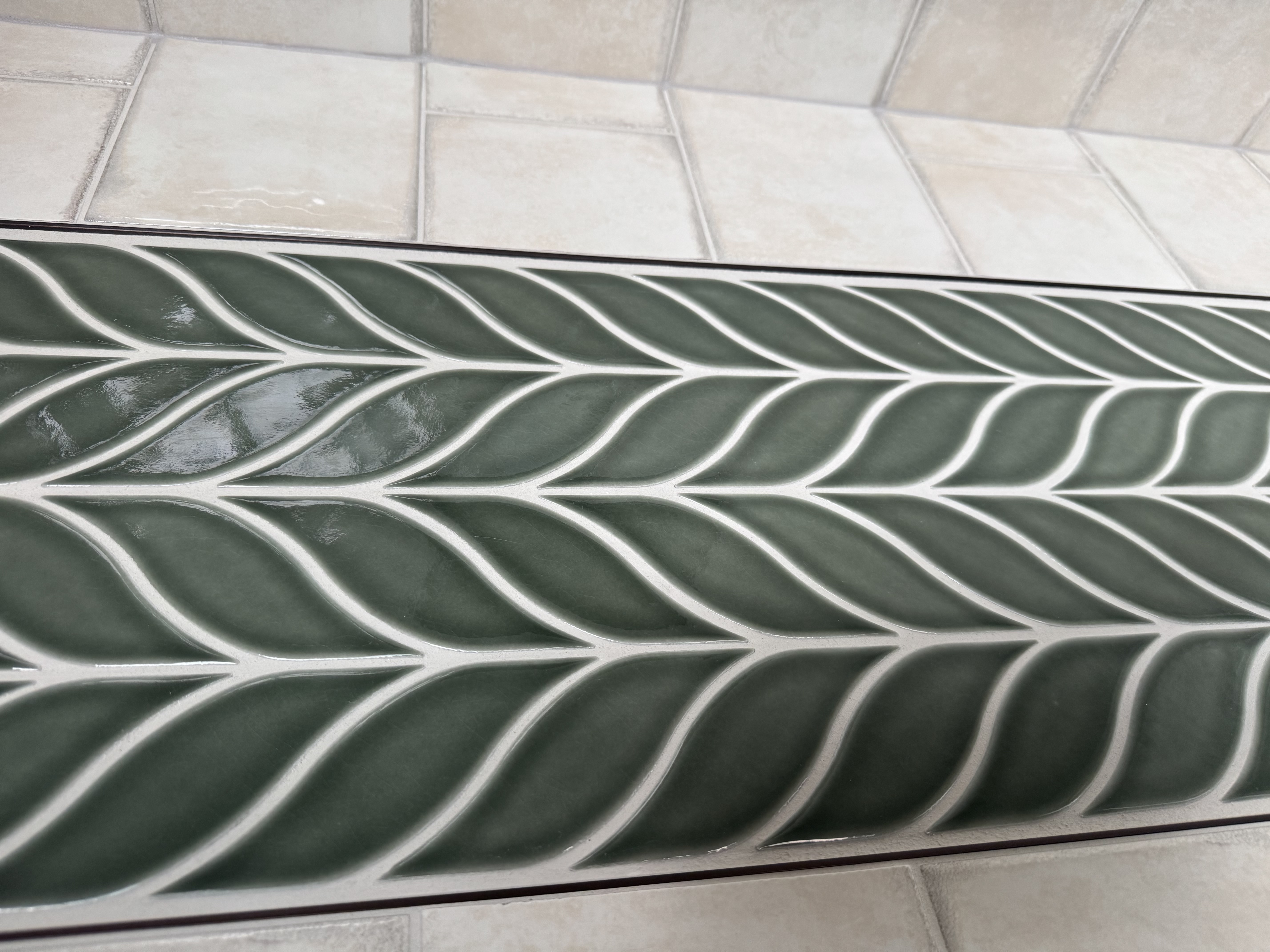 Decorative green leaf tile shower accent by Kelly's Flooring