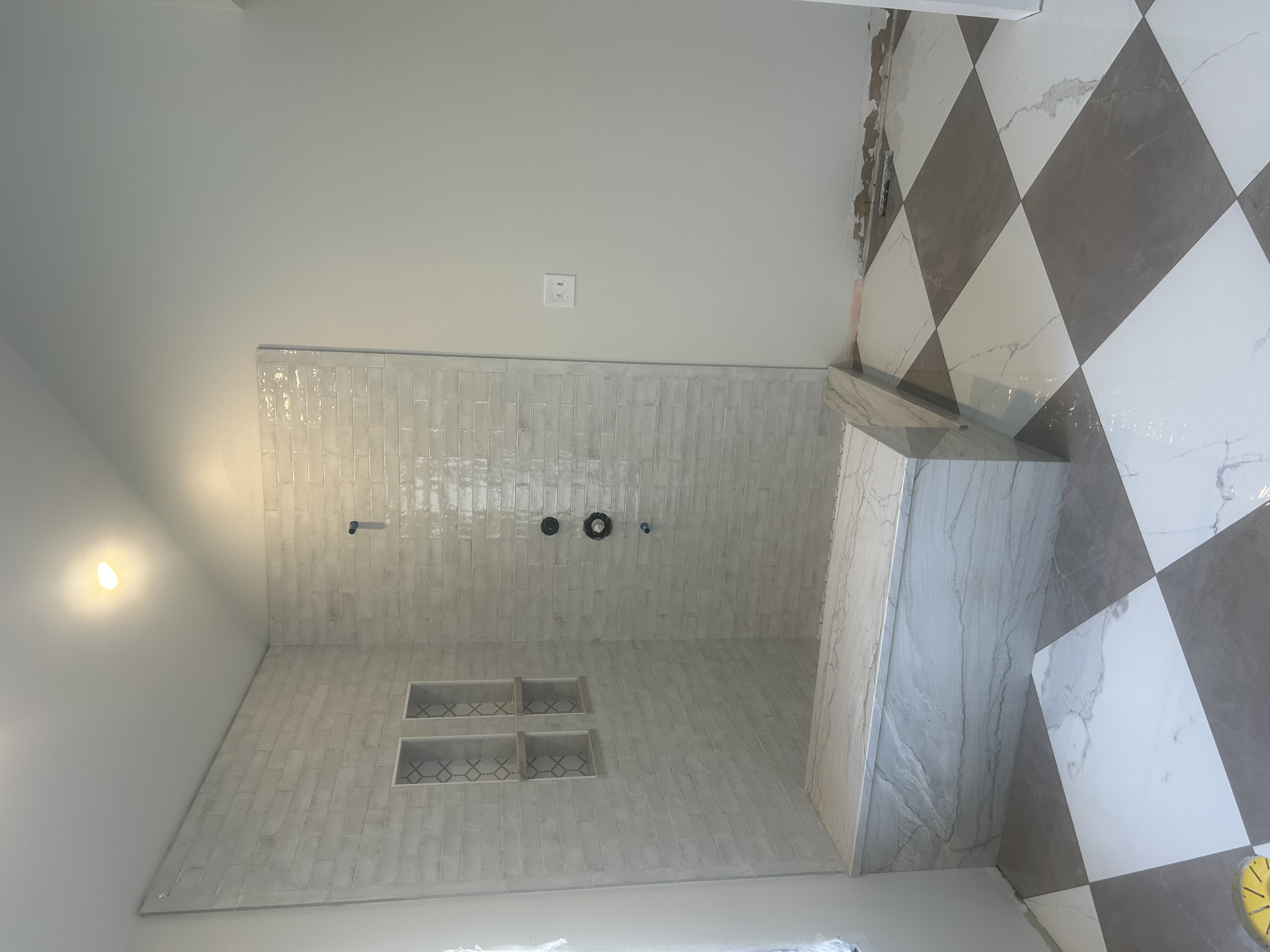 Custom walk-in shower remodel with marble bench and checkerboard tile floor in St. Louis