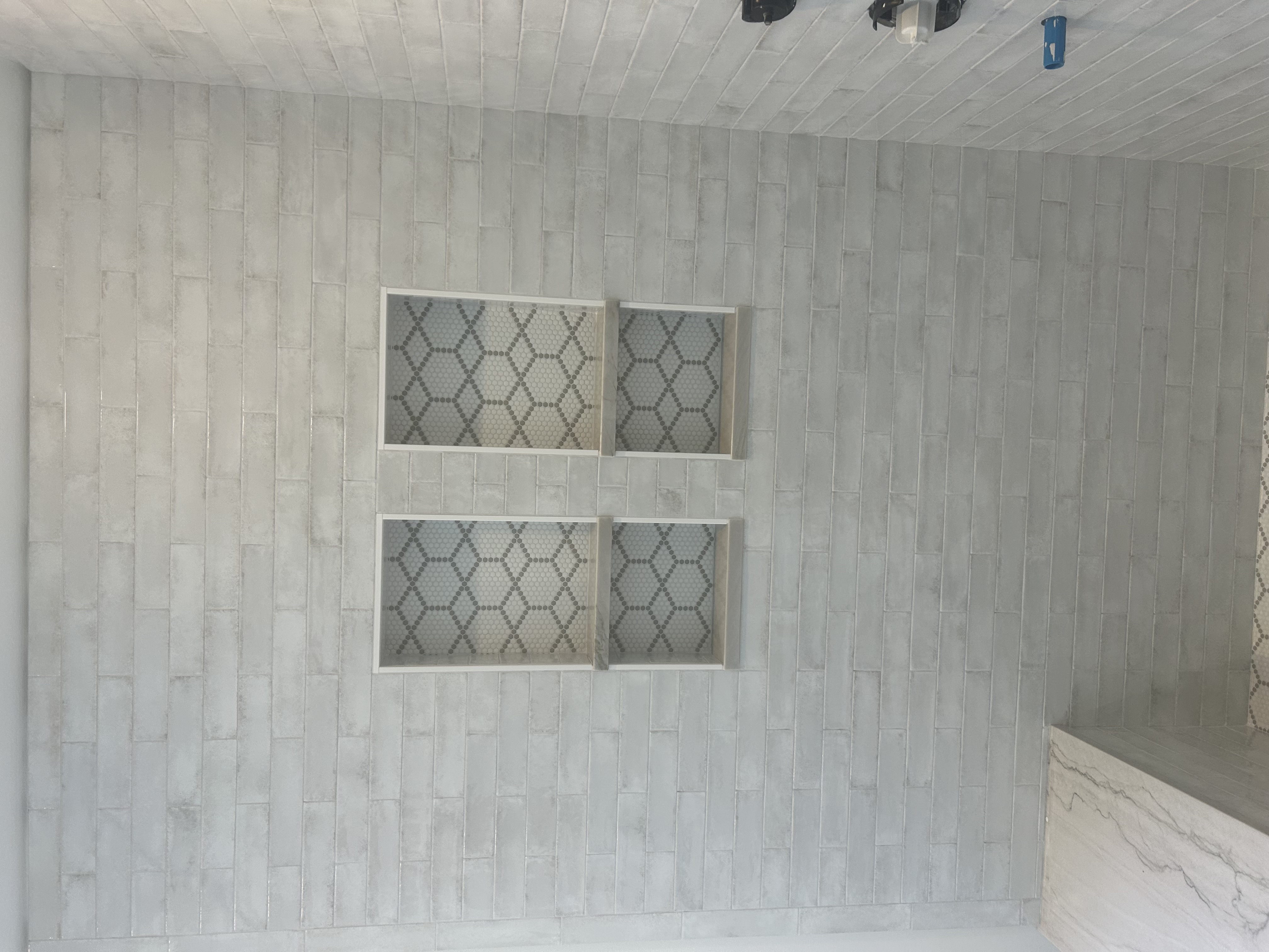 Subway tile shower remodel with decorative hexagon mosaic niches in St. Louis