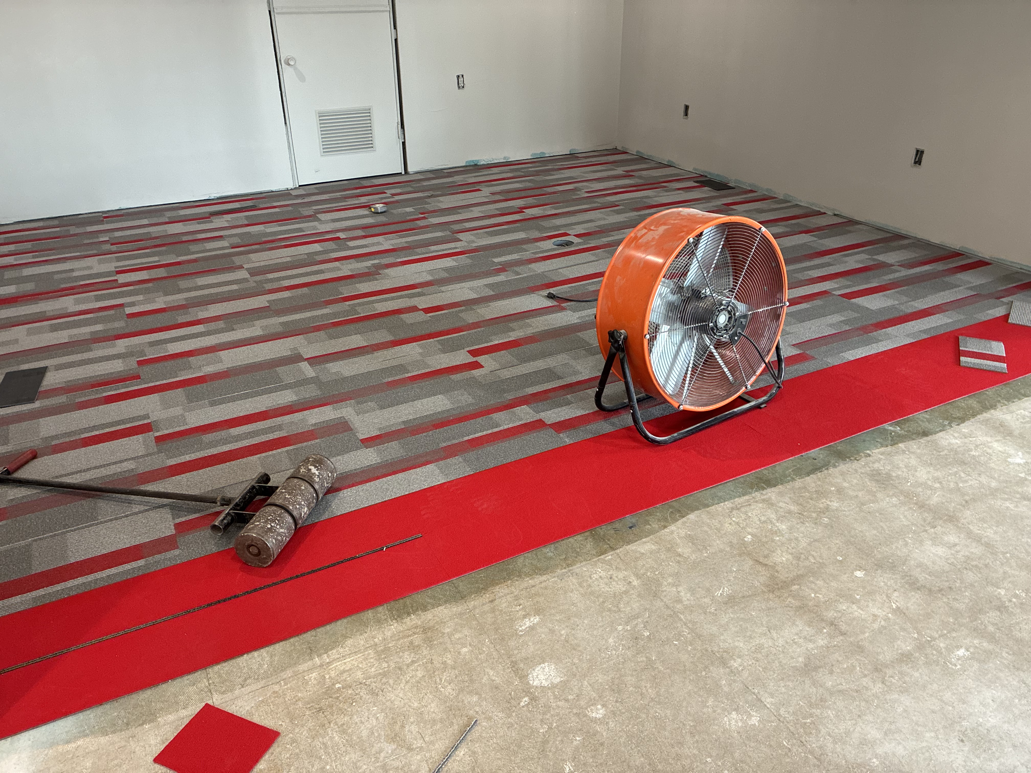 Industrial fan drying glue for proper flash time during commercial flooring installation