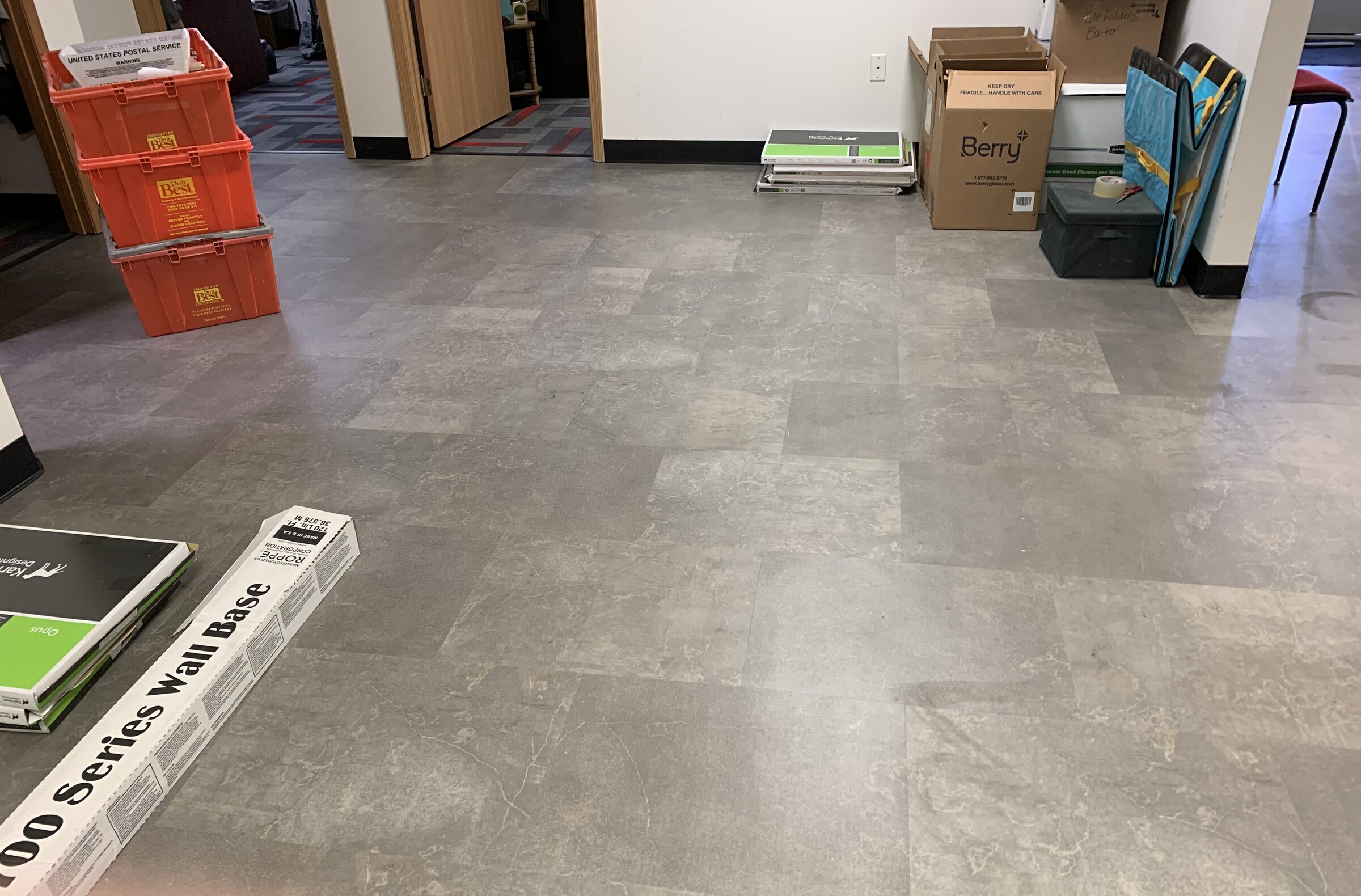 Grey luxury vinyl tile flooring in commercial office hallway