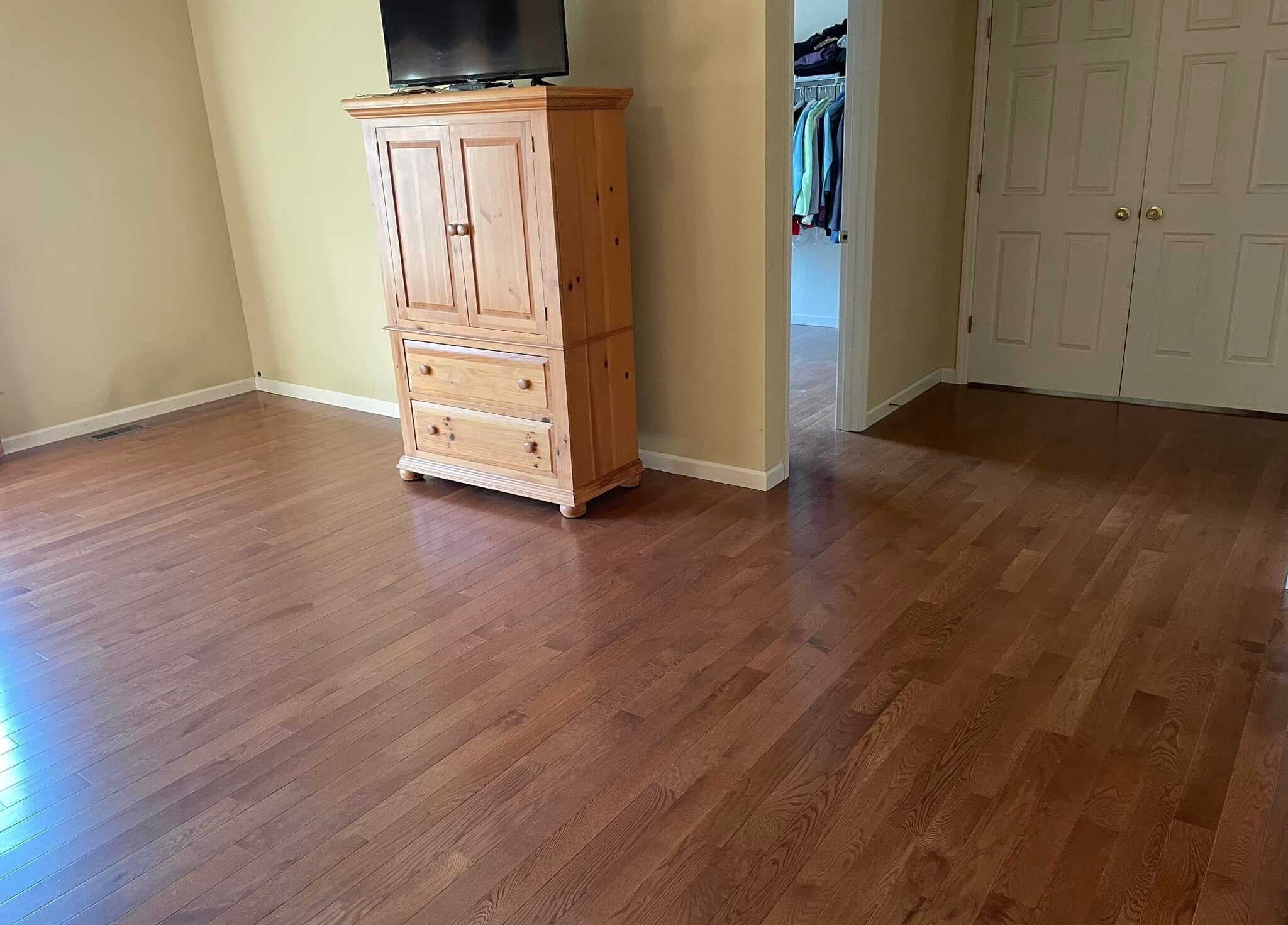 Hardwood flooring in bedroom with armoire