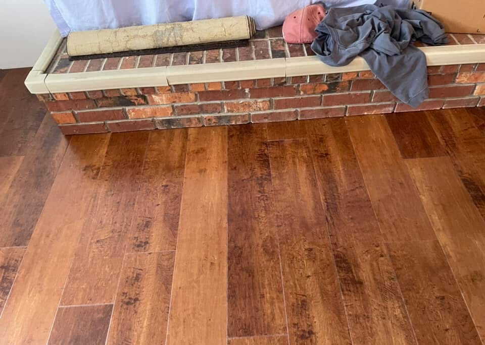 Hardwood flooring next to brick fireplace