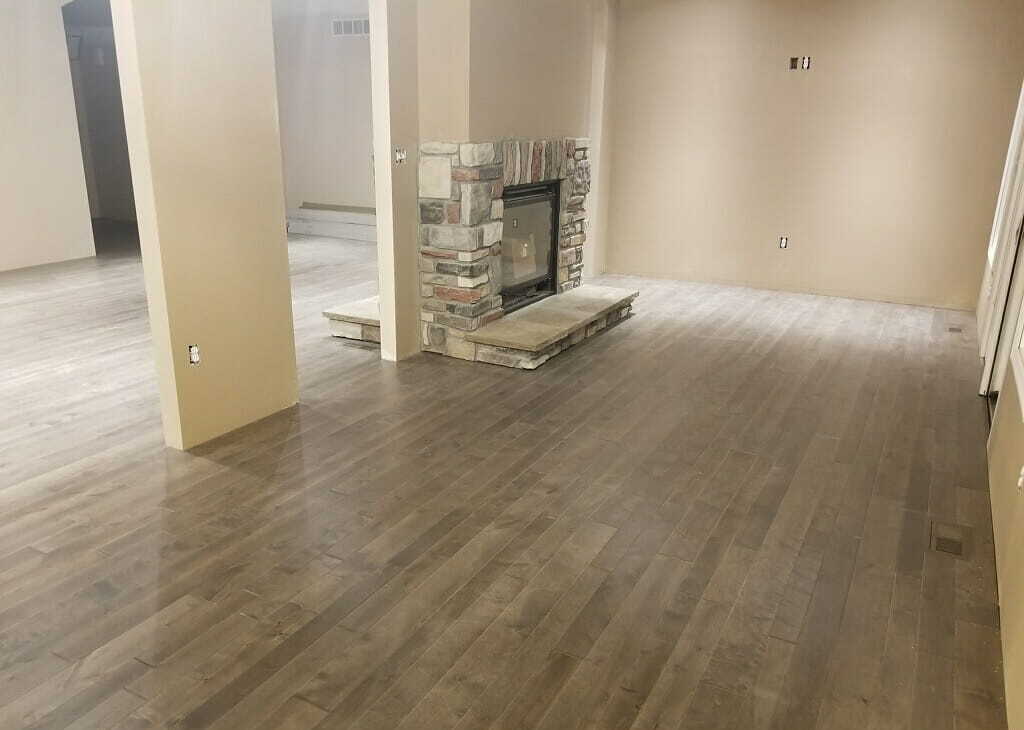 Gray hardwood flooring with stone fireplace