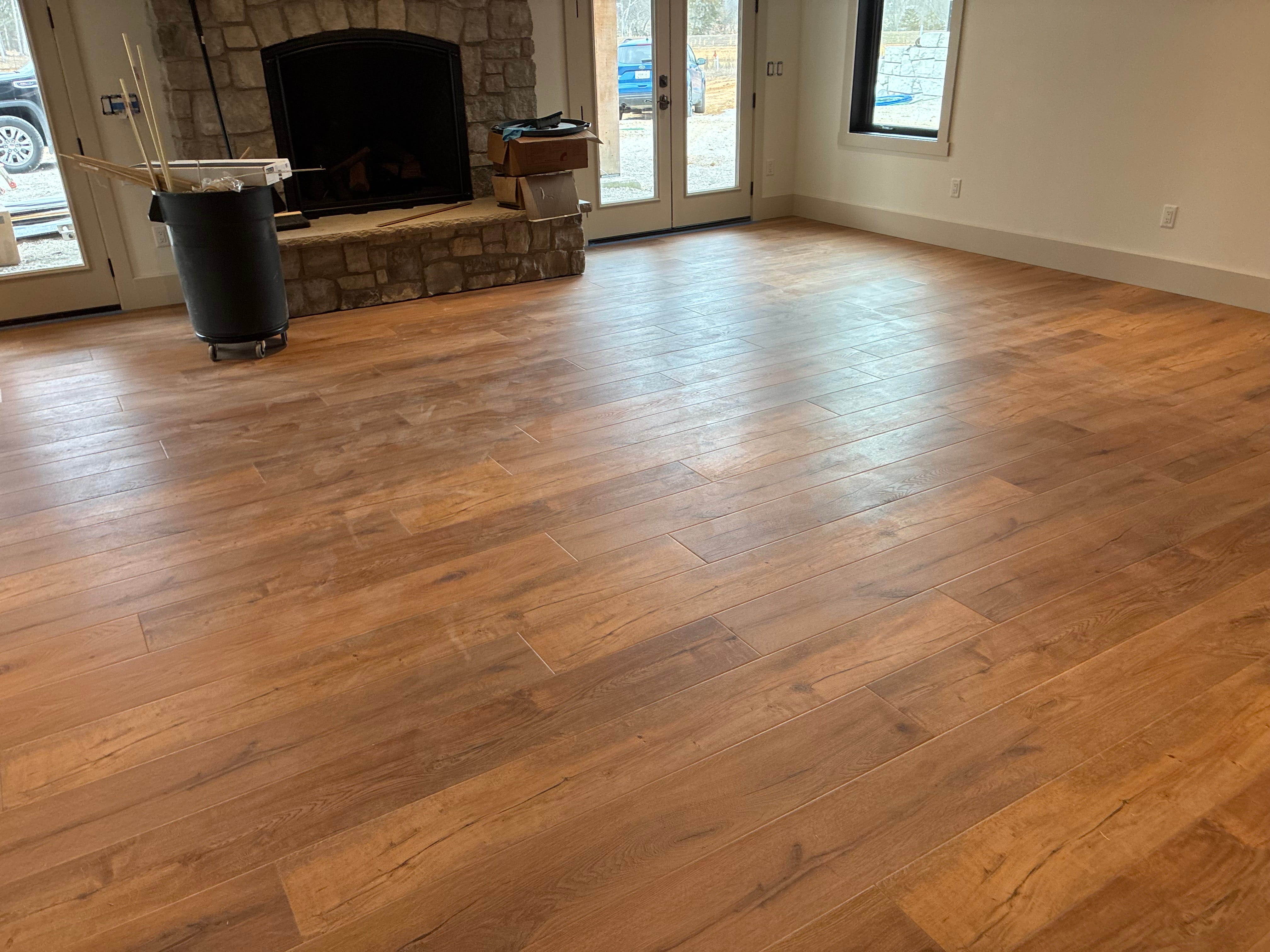 Hardwood flooring in great room with stone fireplace
