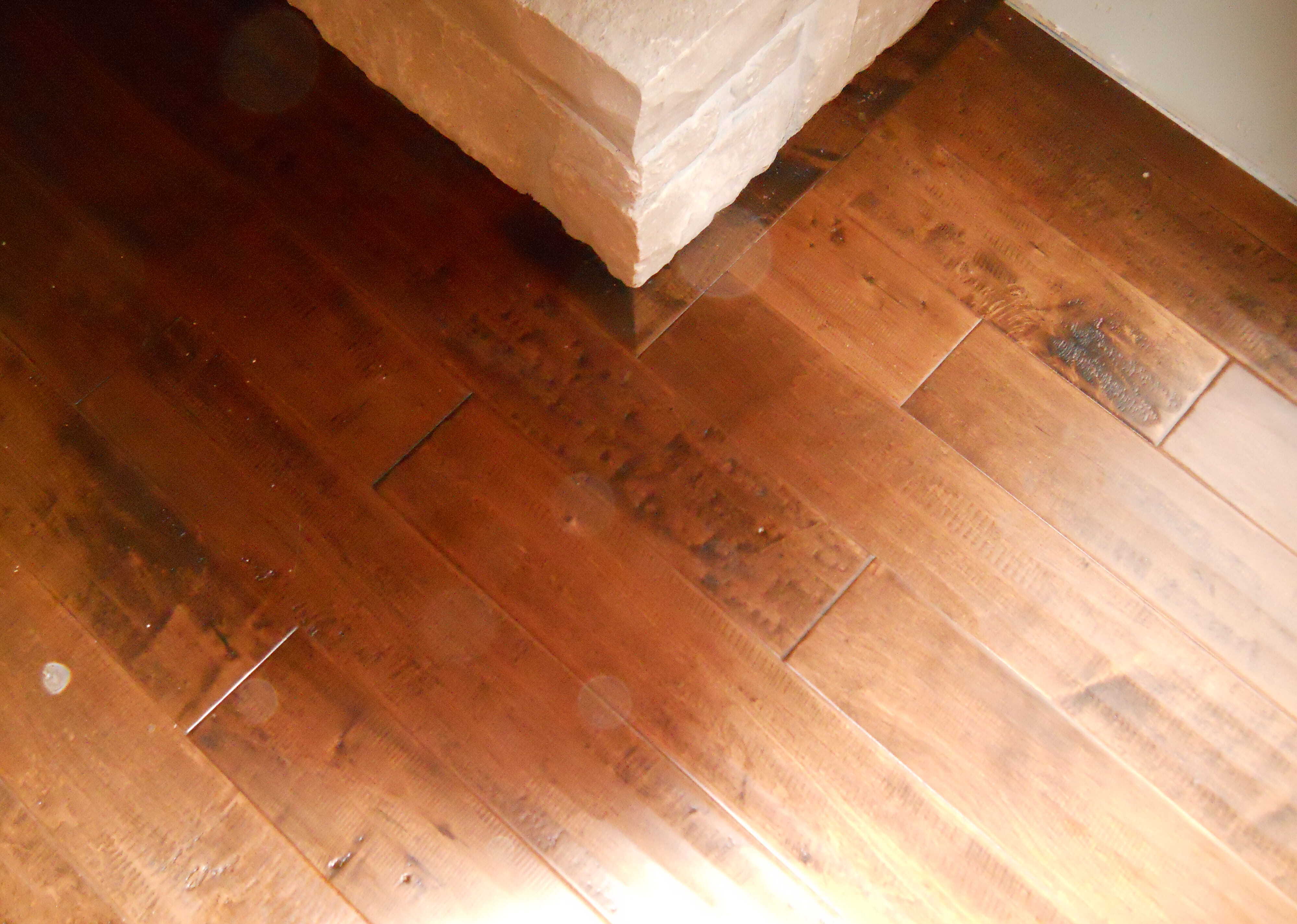 Rich hardwood flooring next to stone fireplace