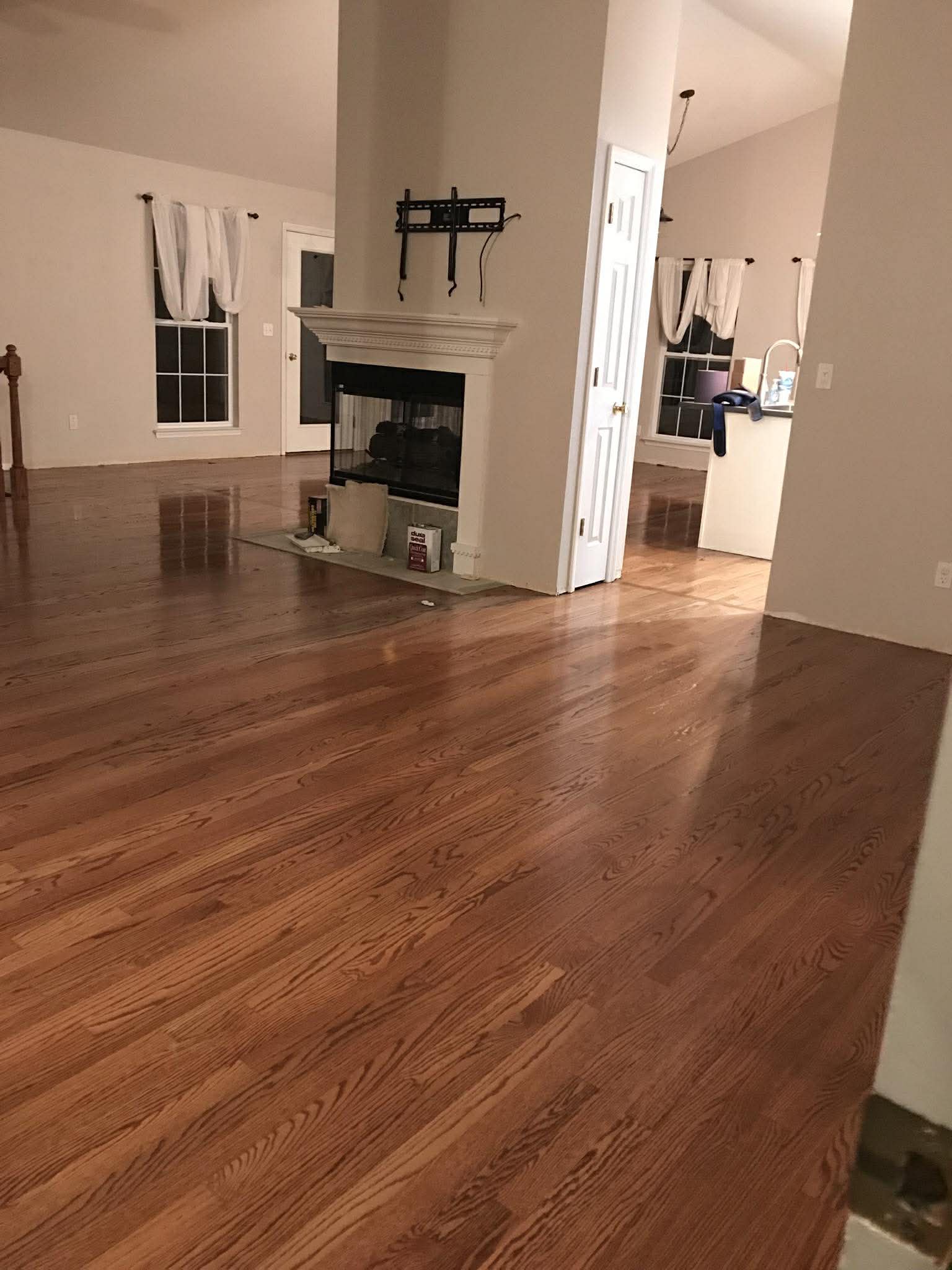 Red oak hardwood flooring in open living room with fireplace