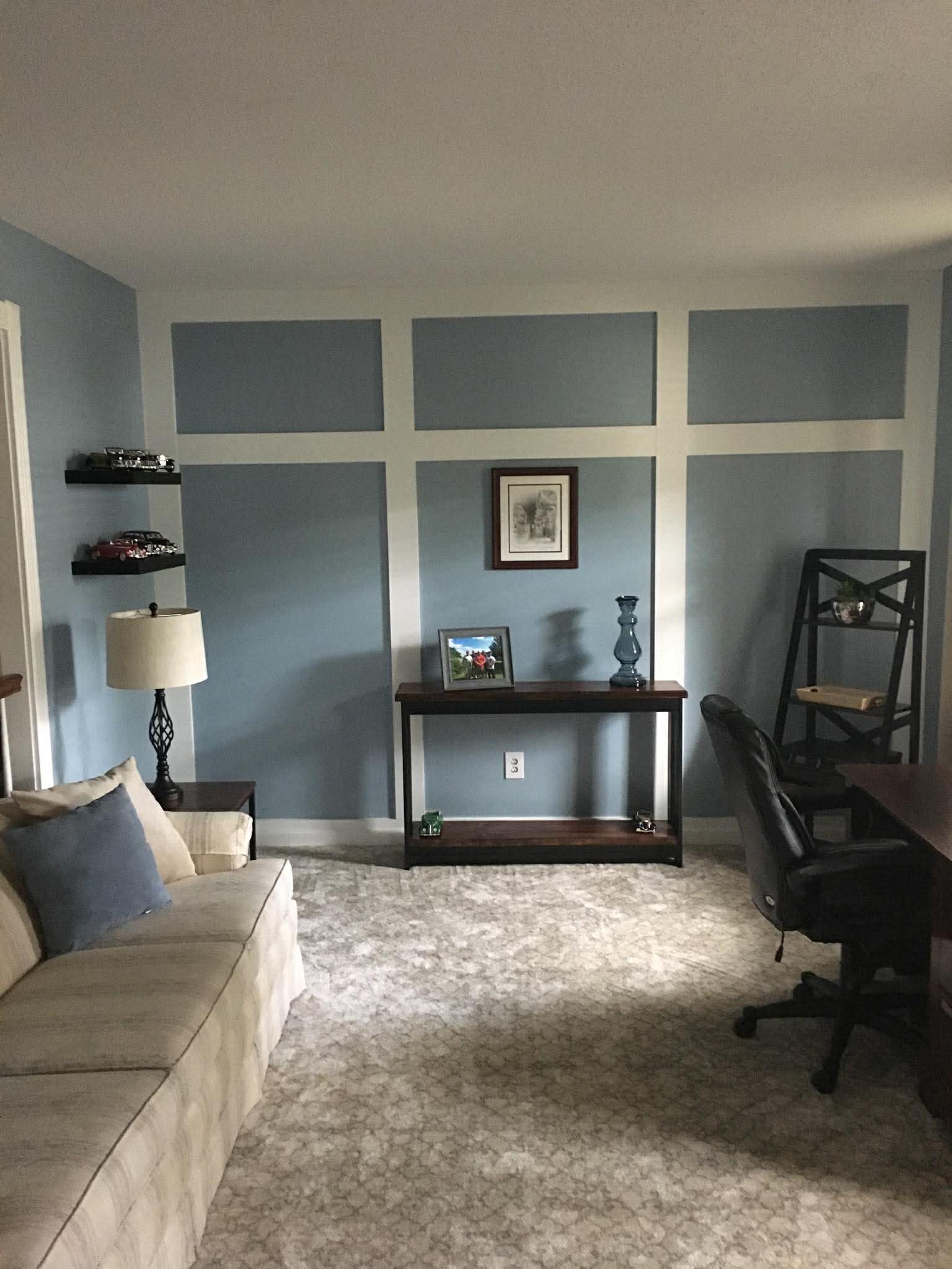 Patterned carpet in furnished living room with blue accent wall