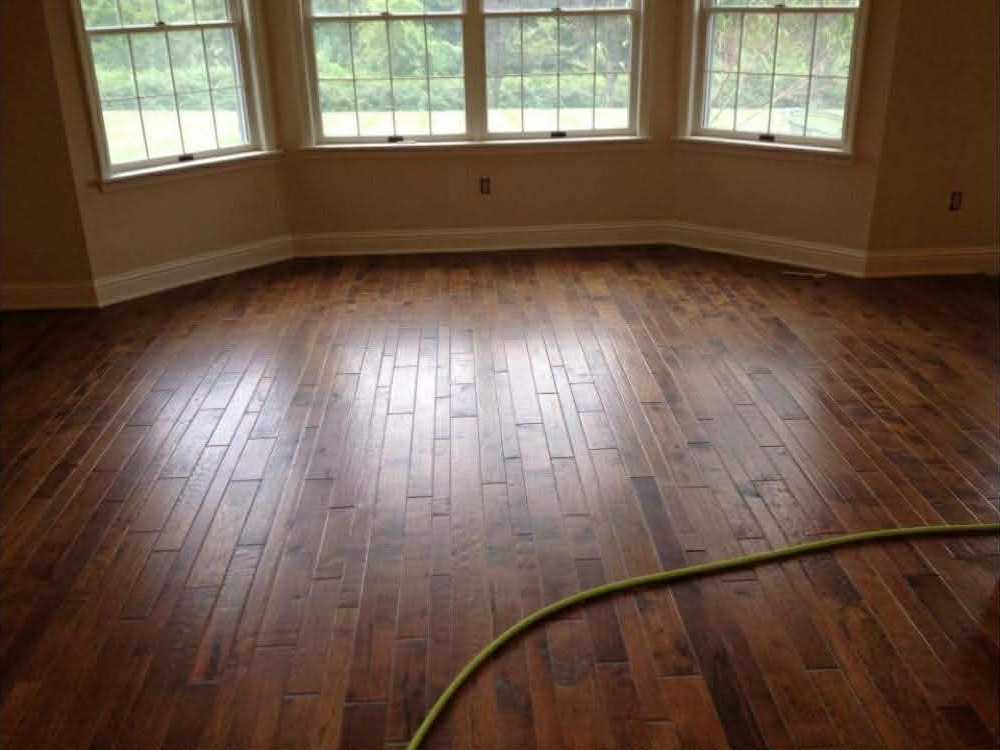 Dark scraped hardwood in bay window room