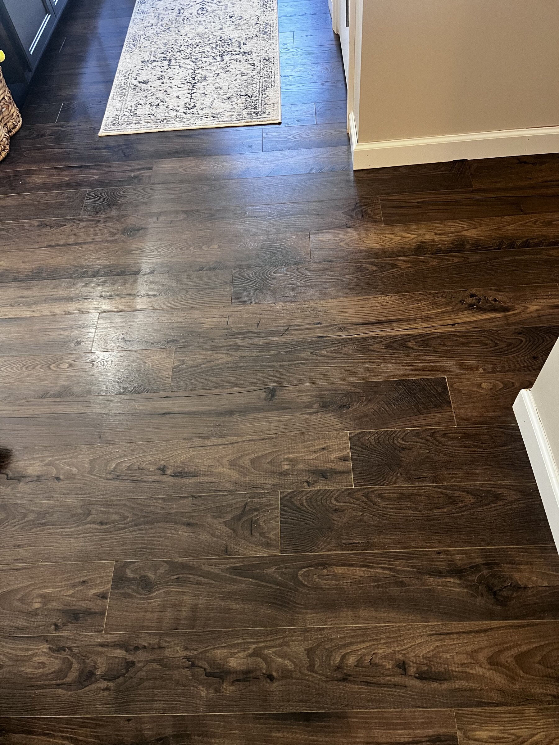 Dark oak laminate flooring in hallway with patterned runner rug
