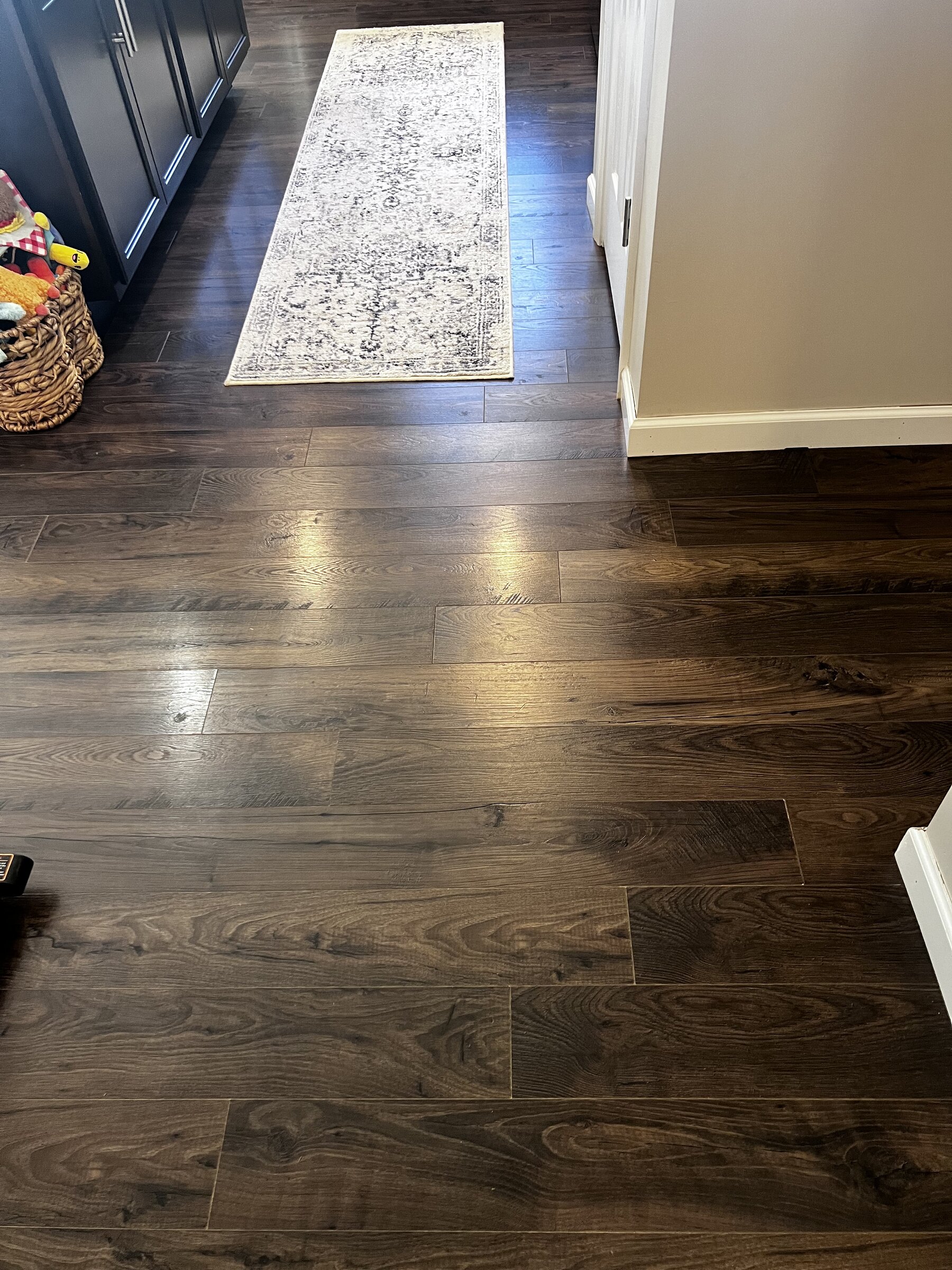 Dark oak laminate flooring in kitchen with patterned runner rug