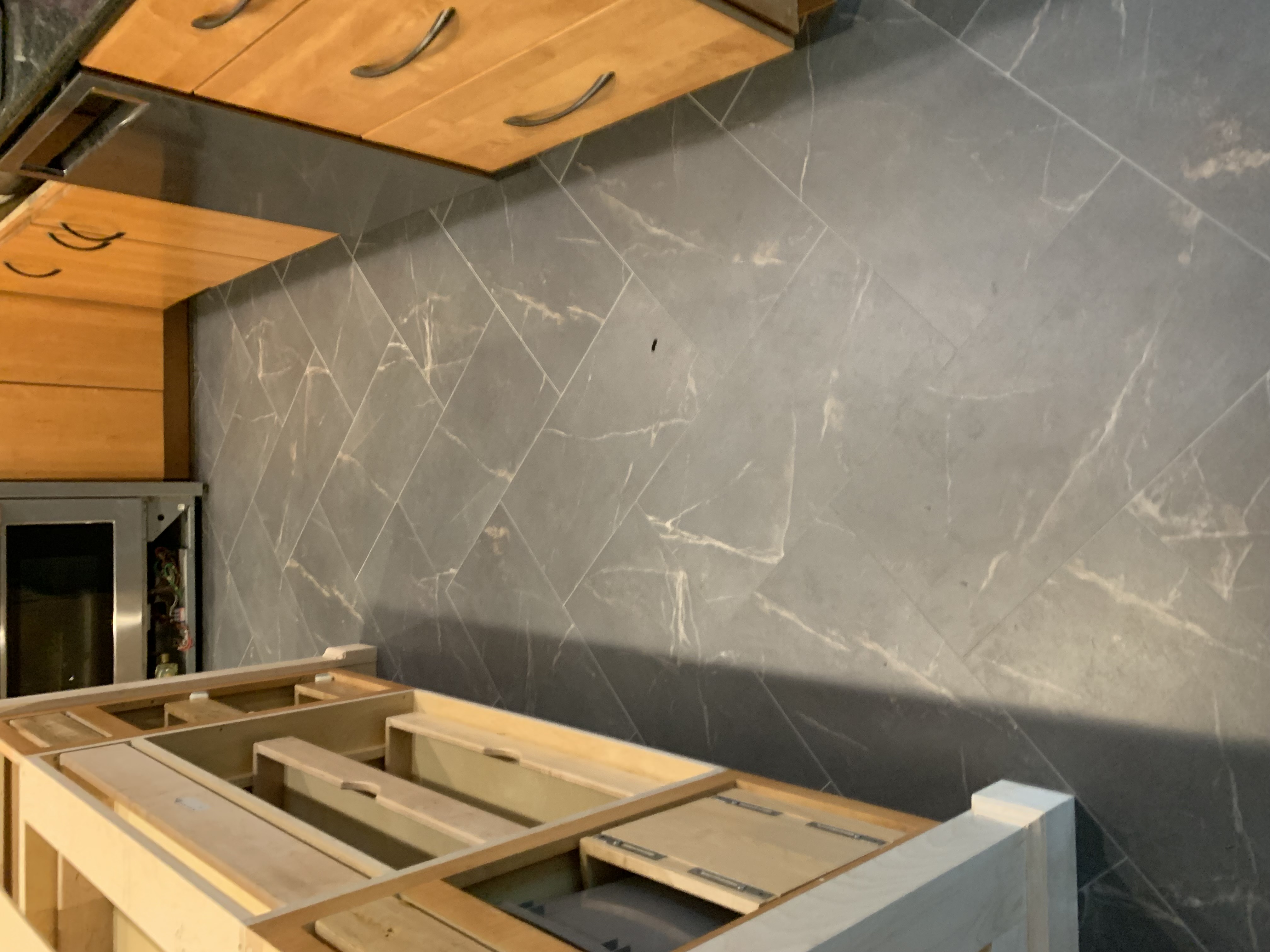 ADURA Flex Baltic Stone kitchen floor with herringbone layout between maple cabinets