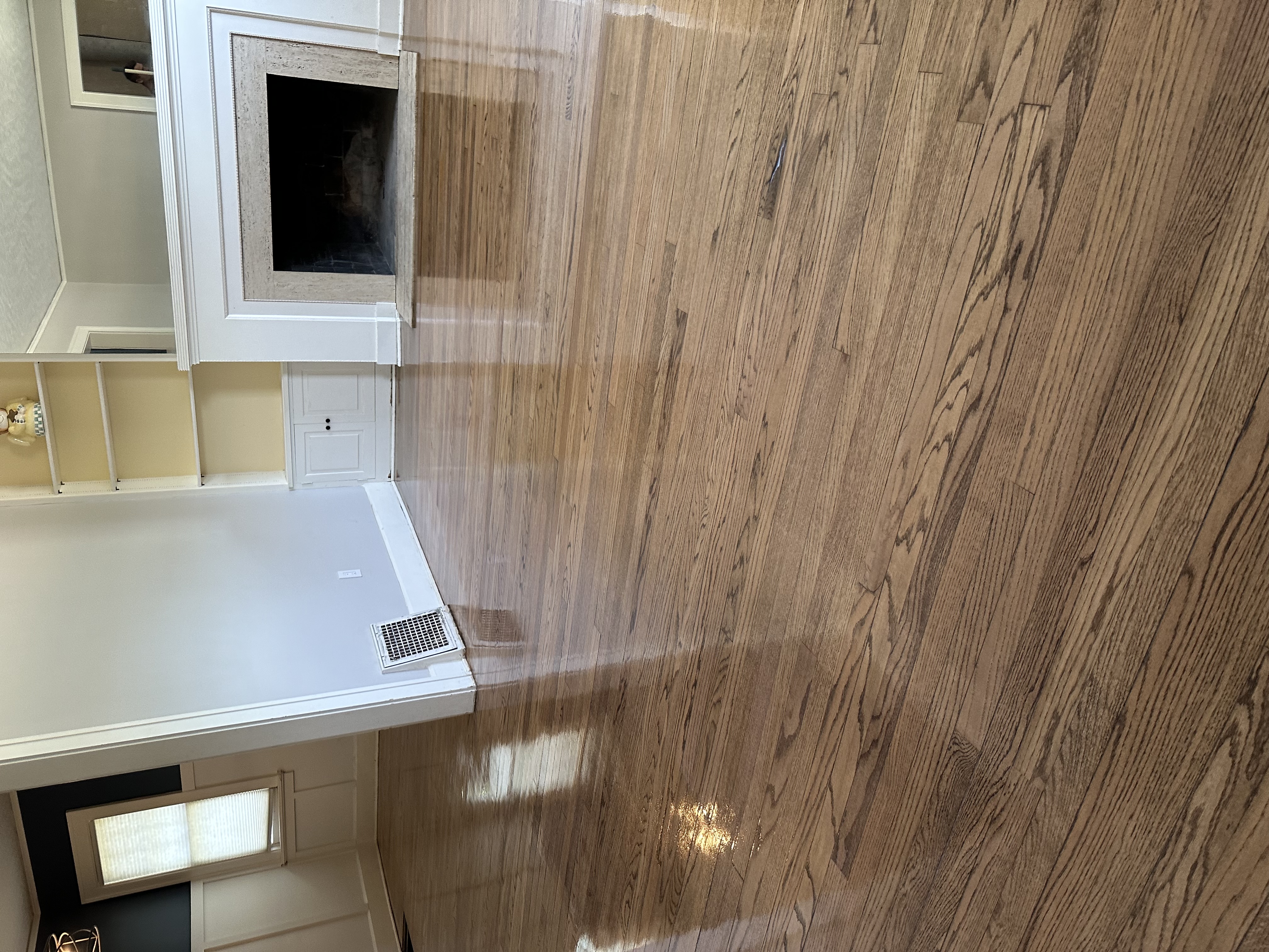 Glossy refinished hardwood floor in living room with fireplace