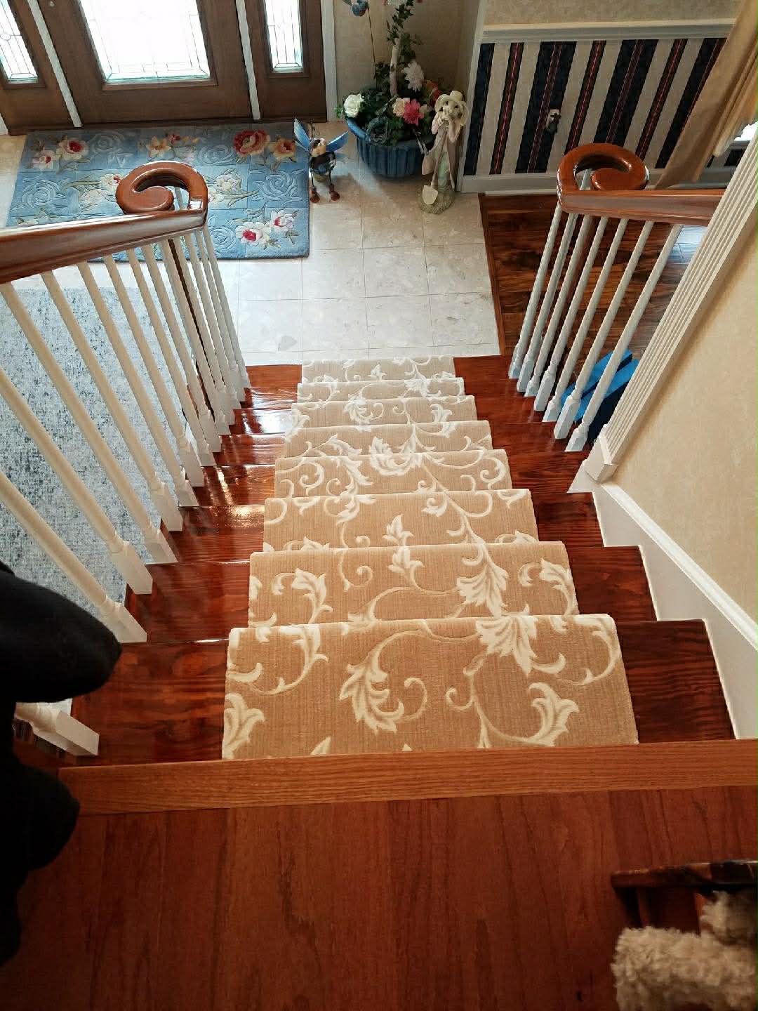 Beige floral scroll carpet on stairs with hardwood trim