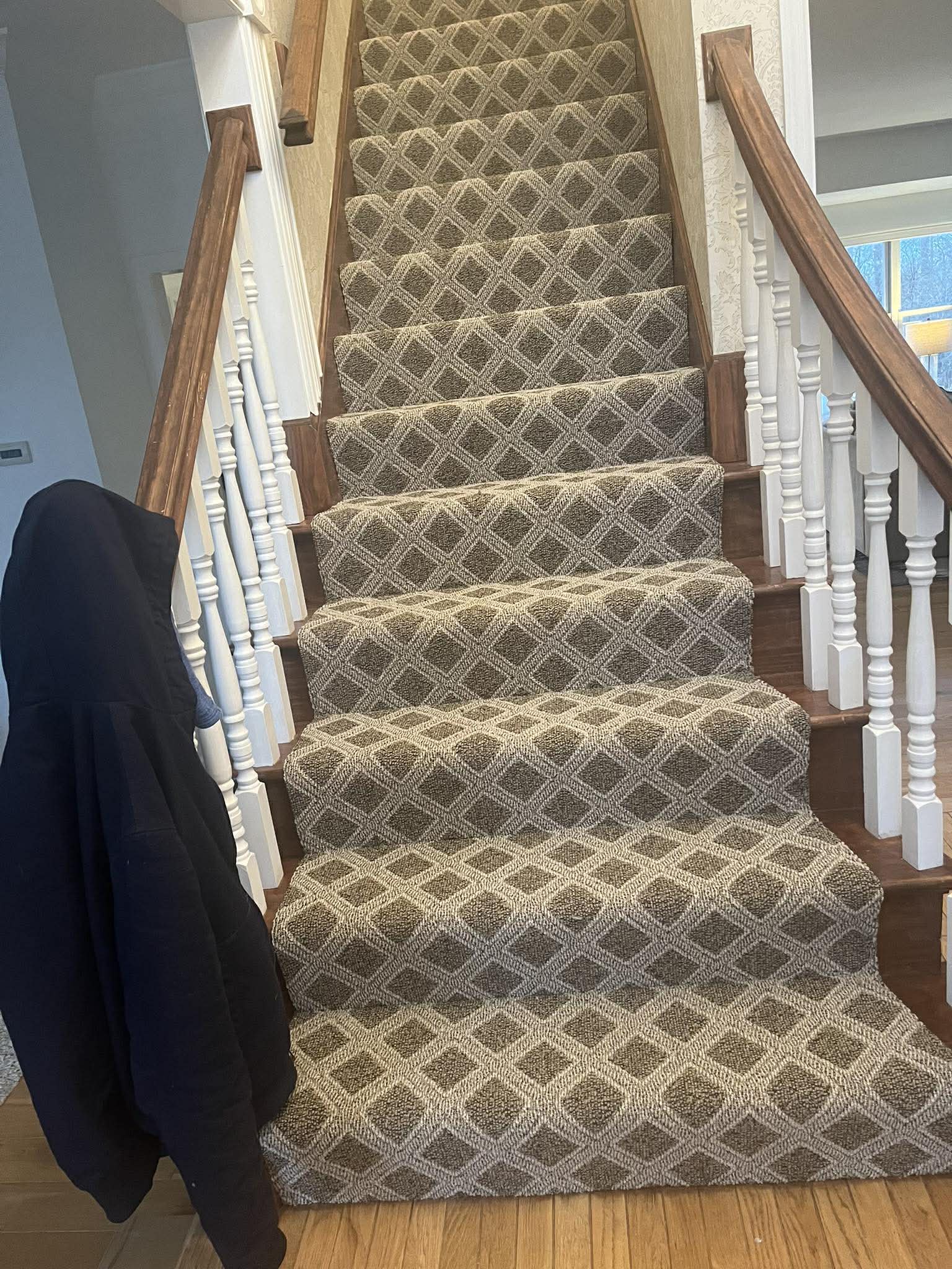 Diamond lattice pattern carpet on stairs with wood railings